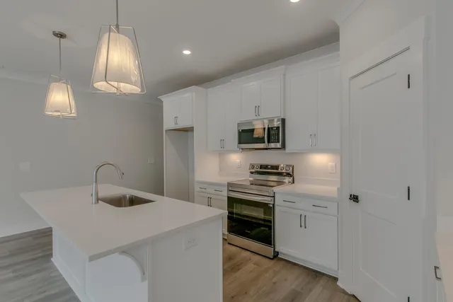 a kitchen with stainless steel appliances a stove refrigerator sink and microwave