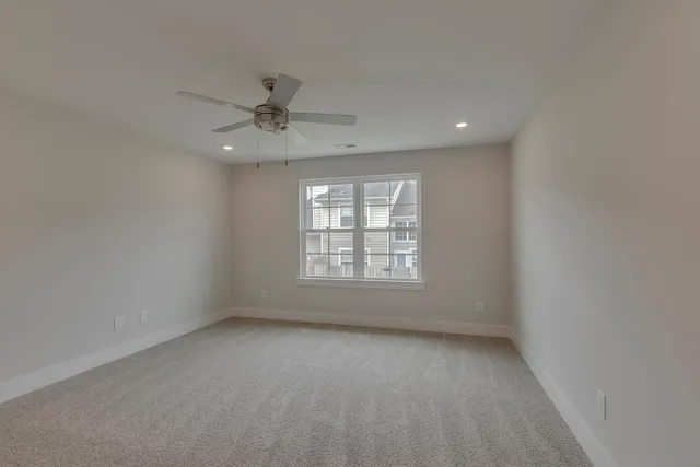 an empty room with a window and a ceiling fan