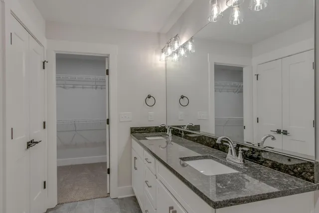 a bathroom with a granite countertop shower sink and mirror