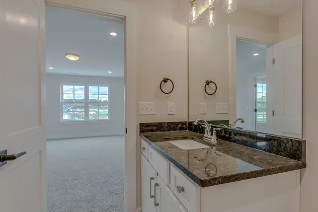 a bathroom with a granite countertop sink a mirror and a shower