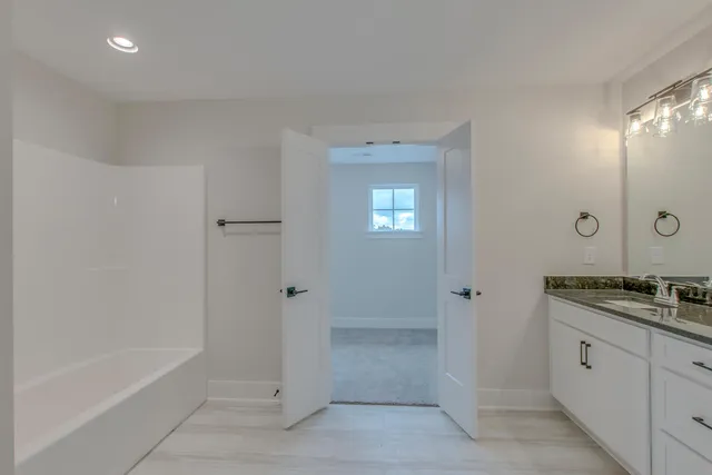 a spacious bathroom with a granite countertop sink a mirror and a shower
