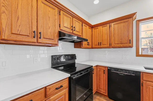 a kitchen with stainless steel appliances granite countertop a refrigerator a sink dishwasher a stove with wooden cabinets and a stove