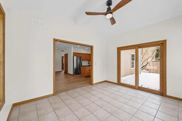 a view of an empty room with a window and a kitchen