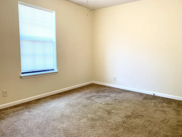 an empty room with windows and closet
