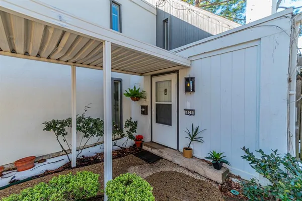 a view of a backyard with chair and potted plants