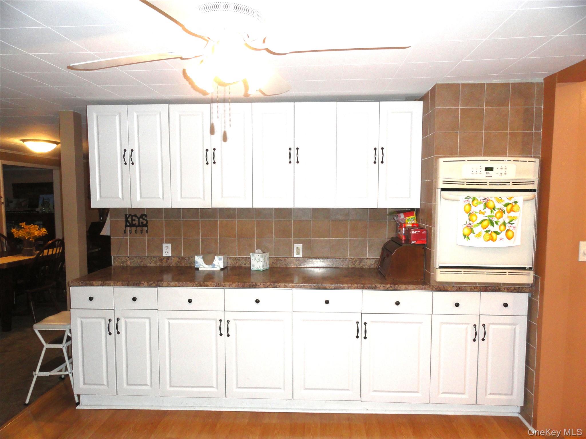 198 Tinkertown Road Salt Point, NY 12578 - Photo 9 of 25 Kitchen with white oven, dark countertops, white cabinetry, and backsplash