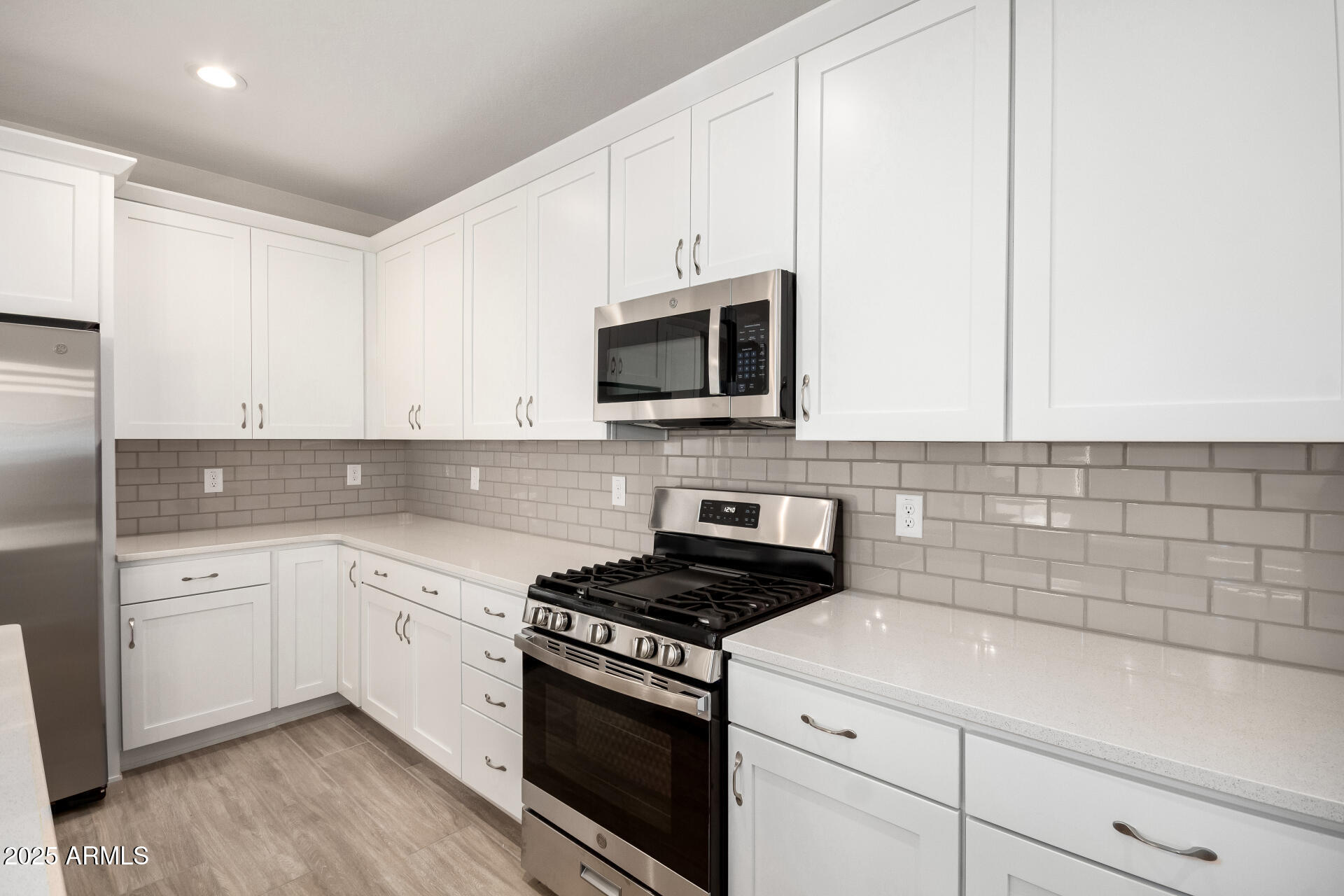 5008 West Roundhouse Road Laveen, AZ 85339 - Photo 4 of 36 a kitchen with white cabinets stainless steel appliances and sink