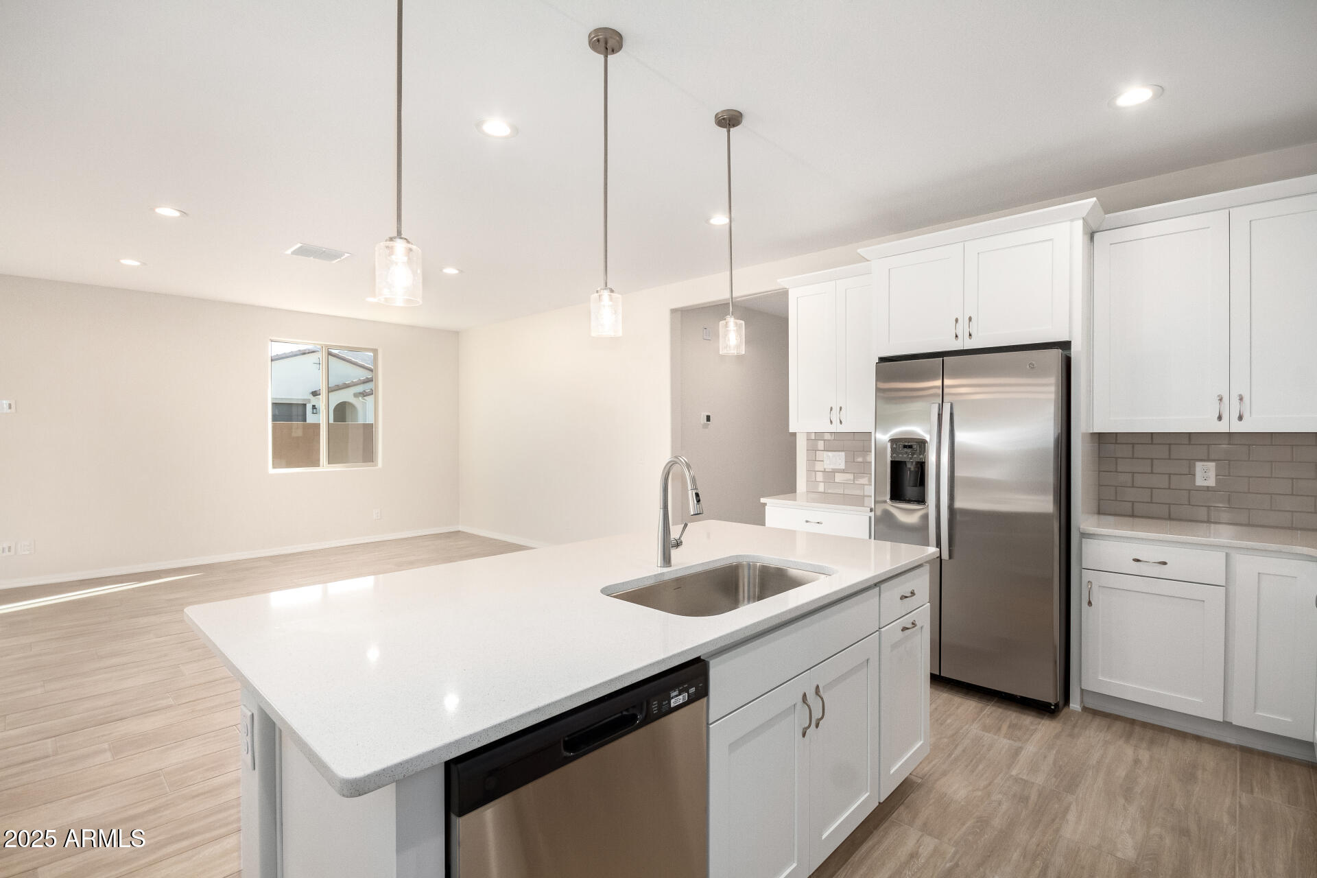 5008 West Roundhouse Road Laveen, AZ 85339 - Photo 5 of 36 a kitchen with stainless steel appliances granite countertop a sink a microwave a refrigerator and white cabinets with wooden floor