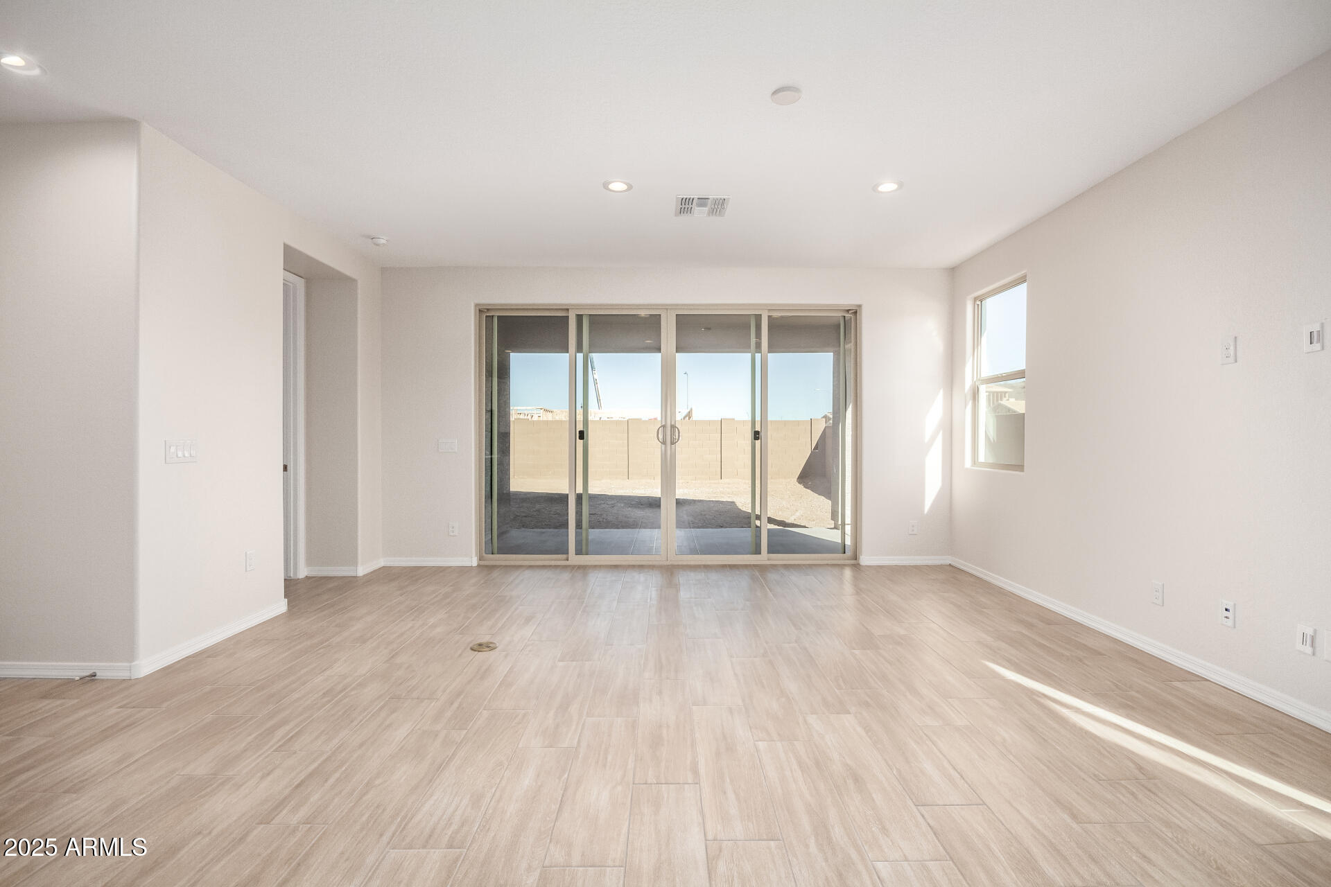 5008 West Roundhouse Road Laveen, AZ 85339 - Photo 8 of 36 an empty room with wooden floor and windows