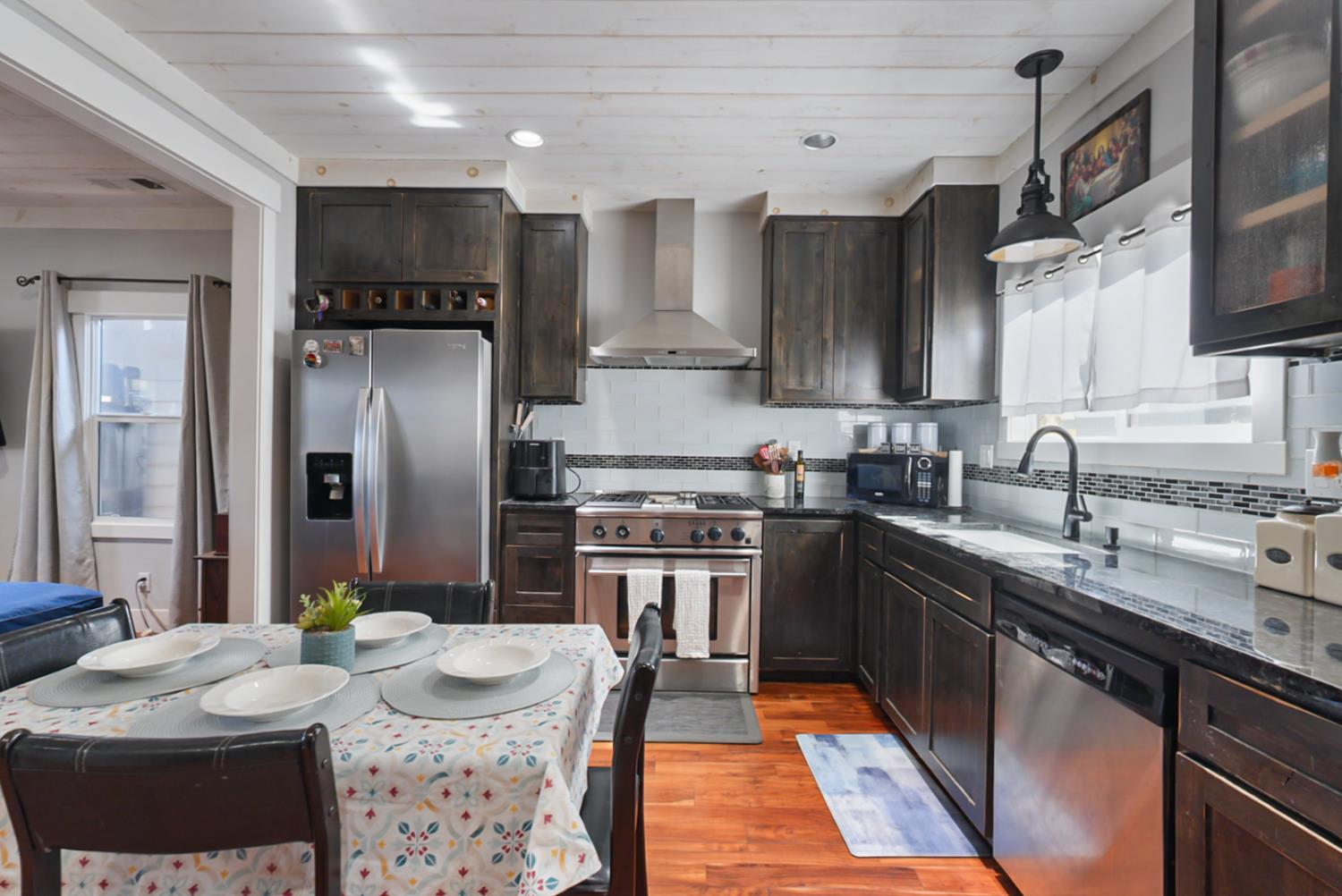 526 Flower Street Turlock, CA 95380 - Photo 7 of 28 a kitchen with stainless steel appliances granite countertop a sink stove and refrigerator