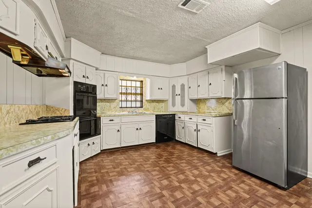 a kitchen with stainless steel appliances a refrigerator sink and cabinets
