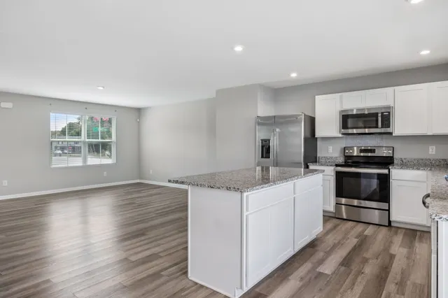 a kitchen with a sink stove cabinets and refrigerator