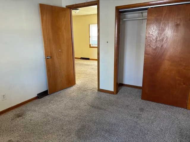 an empty room with closet and wooden floor