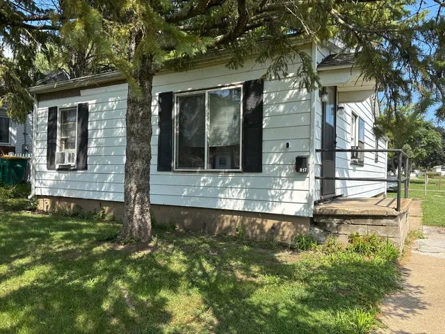 a view of a house with a yard balcony and a tree