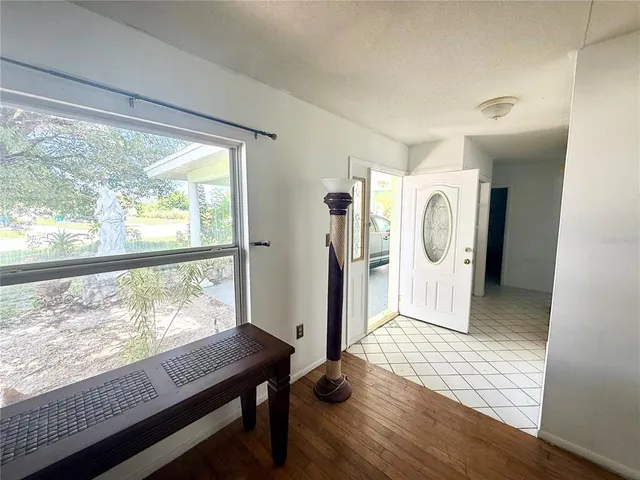 a view of a hallway with wooden floor and windows