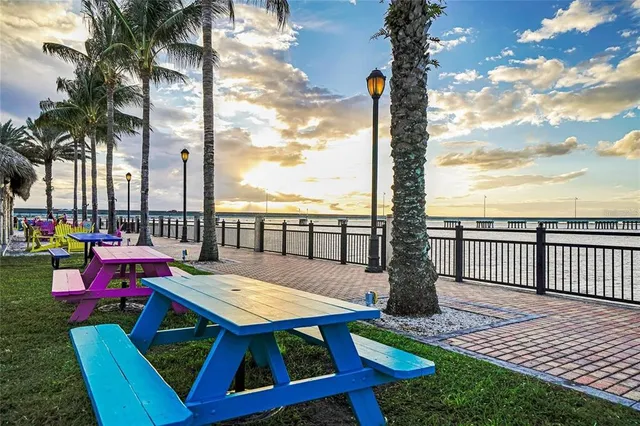a view of deck with a table and chairs couches and wooden fence