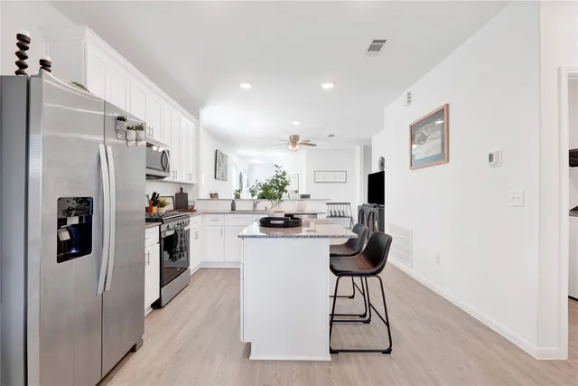 a kitchen with stainless steel appliances kitchen island a refrigerator and a stove