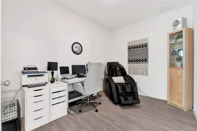 a view of a workspace with furniture and wooden floor