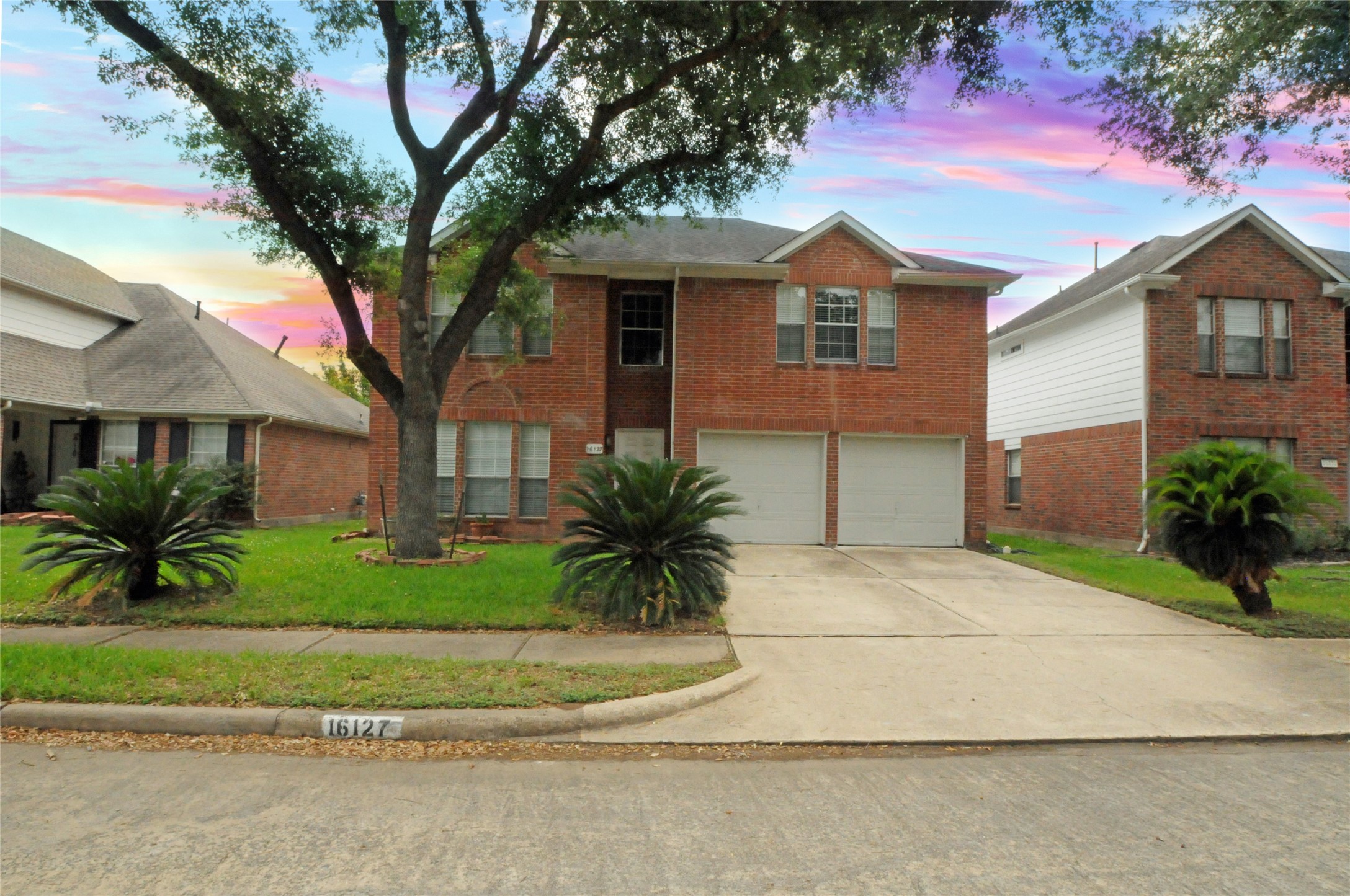 16127 Eaglewood Spring Court Houston, TX 77083 - Photo 1 of 31 a front view of a house with a garden and trees