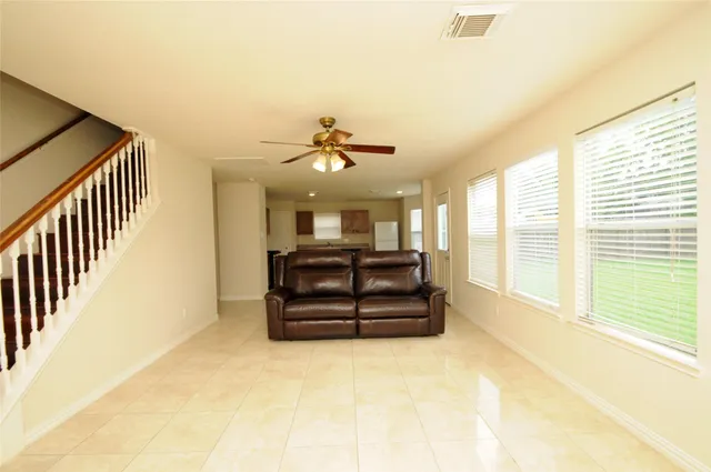 a living room with couch cabinet and a large window