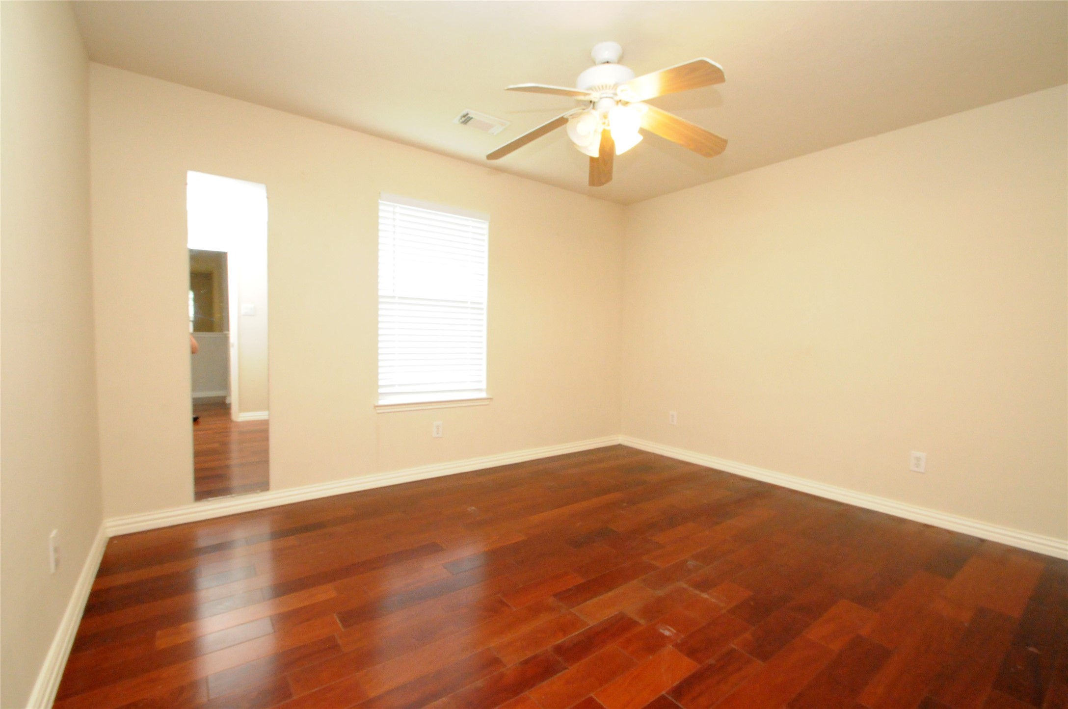 16127 Eaglewood Spring Court Houston, TX 77083 - Photo 21 of 31 an empty room with wooden floor fan and window