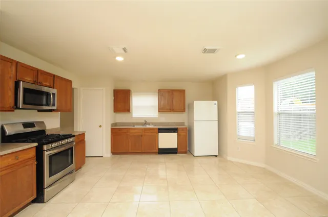 a kitchen with a stove a sink and a refrigerator