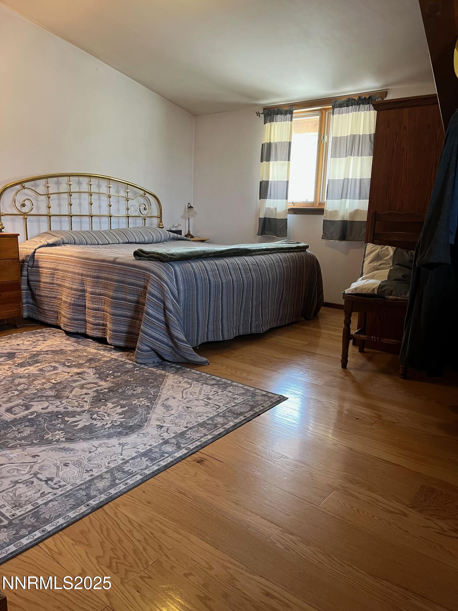3350 Ikes Cyn Road Round Mountain, NV 89045 - Photo 24 of 38 a bedroom with furniture window and a wooden floor