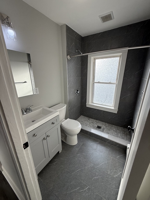 1922 Columbus Avenue, Unit 3 Boston, MA 02119 - Photo 19 of 22 a bathroom with a double vanity sink toilet mirror and window