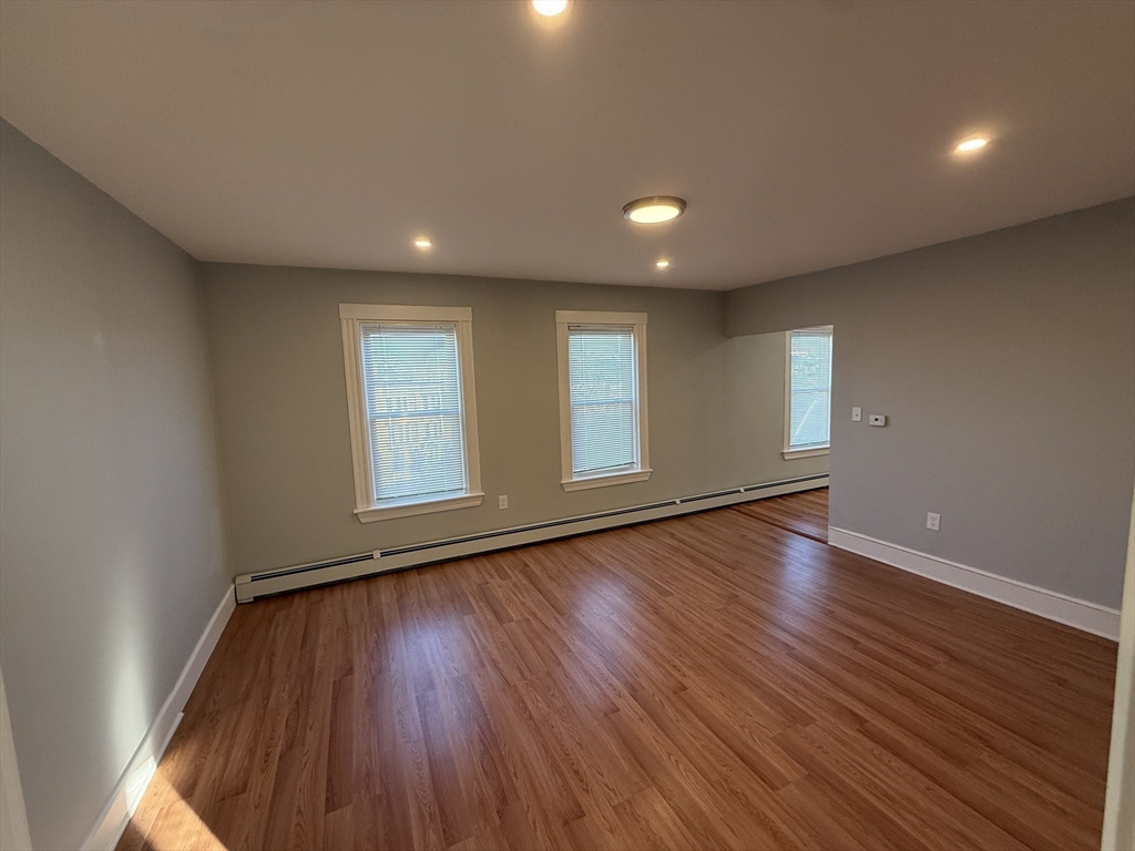 1922 Columbus Avenue, Unit 3 Boston, MA 02119 - Photo 4 of 22 a view of an empty room with wooden floor and a window