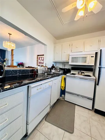 a kitchen with appliances a sink and cabinets