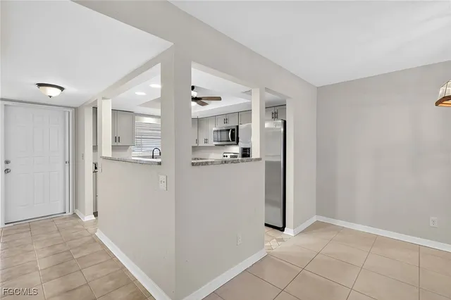 a view of a kitchen with refrigerator and white walls