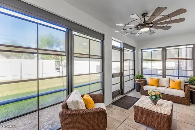 a living room with furniture and floor to ceiling windows