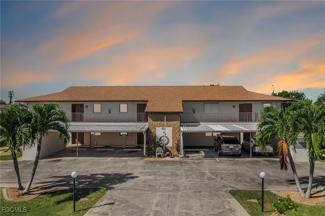 a front view of a house with cars parked