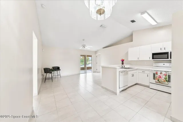 a kitchen with granite countertop a stove a sink and a refrigerator