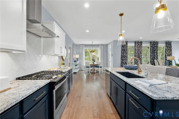 a kitchen with granite countertop a sink stove and cabinets