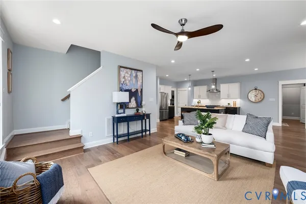 a living room with furniture kitchen view and a chandelier