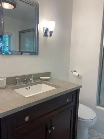 a bathroom with a granite countertop shower and a sink