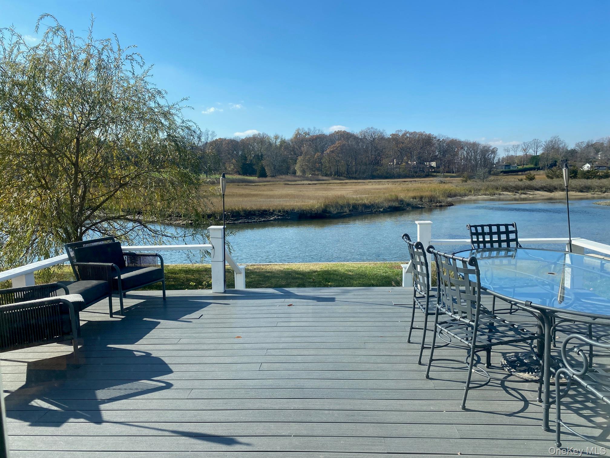 329 Centre Island Road Centre Island, NY 11771 - Photo 24 of 28 a view of a lake with table and chairs