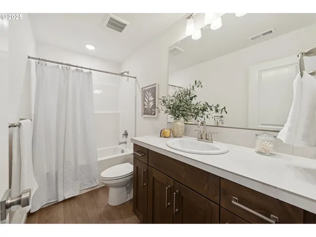a bathroom with a double vanity sink toilet and a mirror