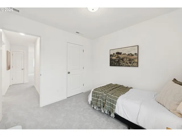 a bedroom with a bed and a painting on the wall