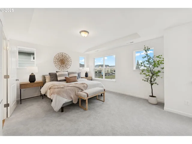 a spacious bedroom with a bed lamp and a potted plant