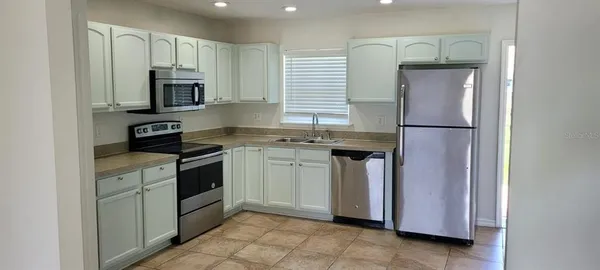a kitchen with stainless steel appliances granite countertop a refrigerator sink and stove