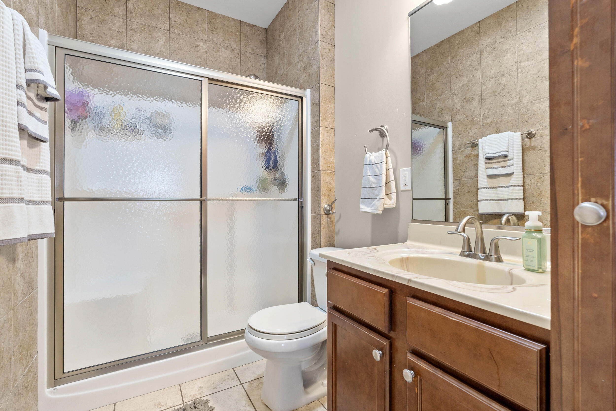 548 Aster Lane Griffith, IN 46319 - Photo 14 of 20 a bathroom with a granite countertop sink toilet a mirror a vanity and shower