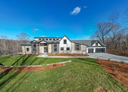 a aerial view of a house with swimming pool and next to a yard