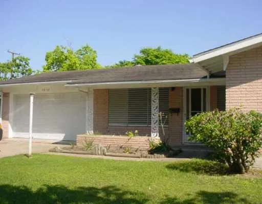 a front view of a house with a yard and potted plants