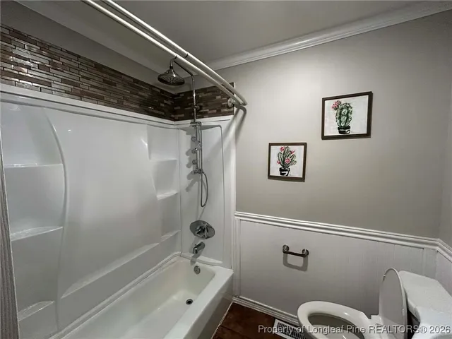 an empty room with wooden floor closet and windows