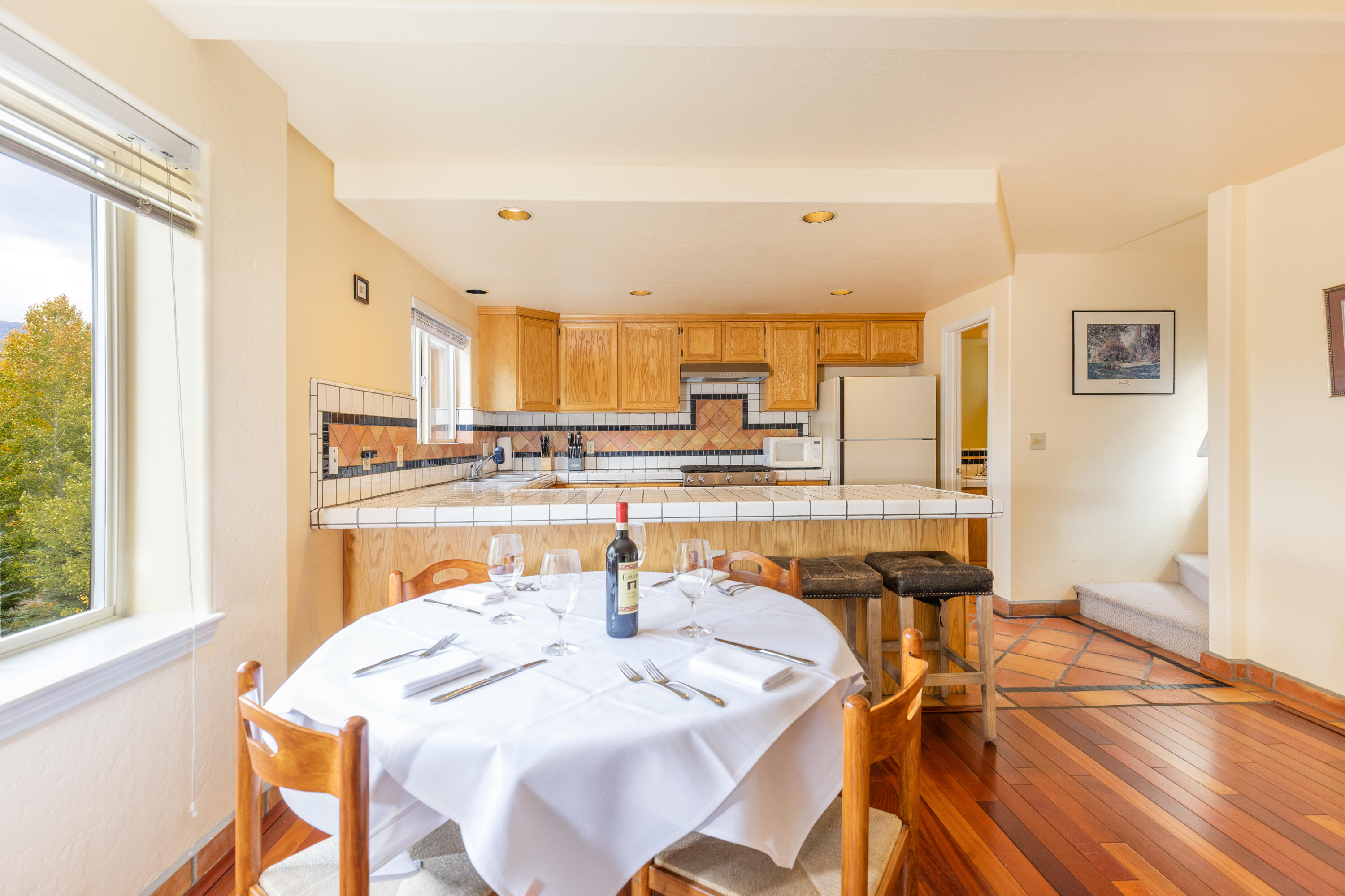 464 San Miguel Ridge, Unit 1 Telluride, CO 81435 - Photo 9 of 27 a open dining room with stainless steel appliances kitchen island granite countertop a sink and cabinets with wooden floor