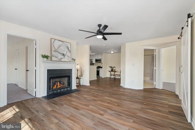 a view of an empty room with wooden floor a fireplace