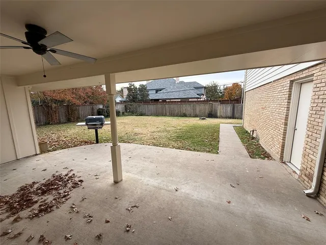 a view of a house with a patio and wooden fence