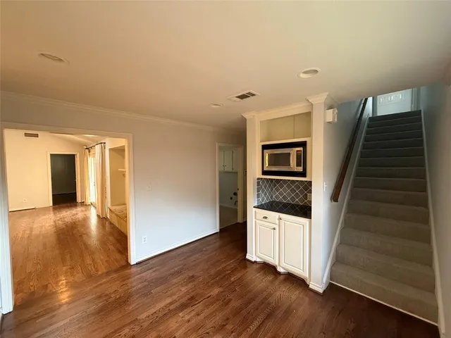 a view of a hallway with wooden floor and stairs